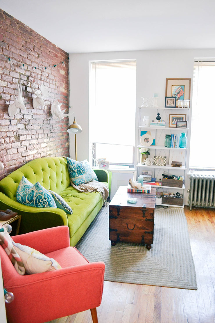 top 10 popular posts of 2015 from Advicefroma20Something.com, boho living room, nyc apartment tour, colorful living room, colorful decor ideas, green couch, velvet couch, animal heads, wooden trunk coffee table