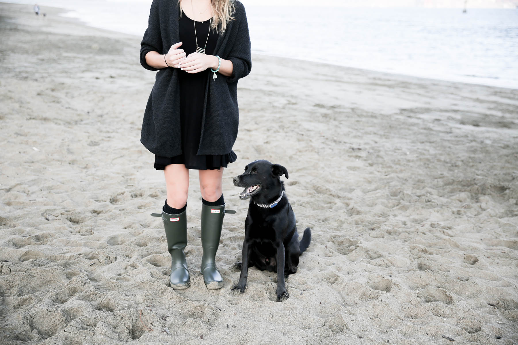 black lab on the beach with Amanda Holstein in hunter boots