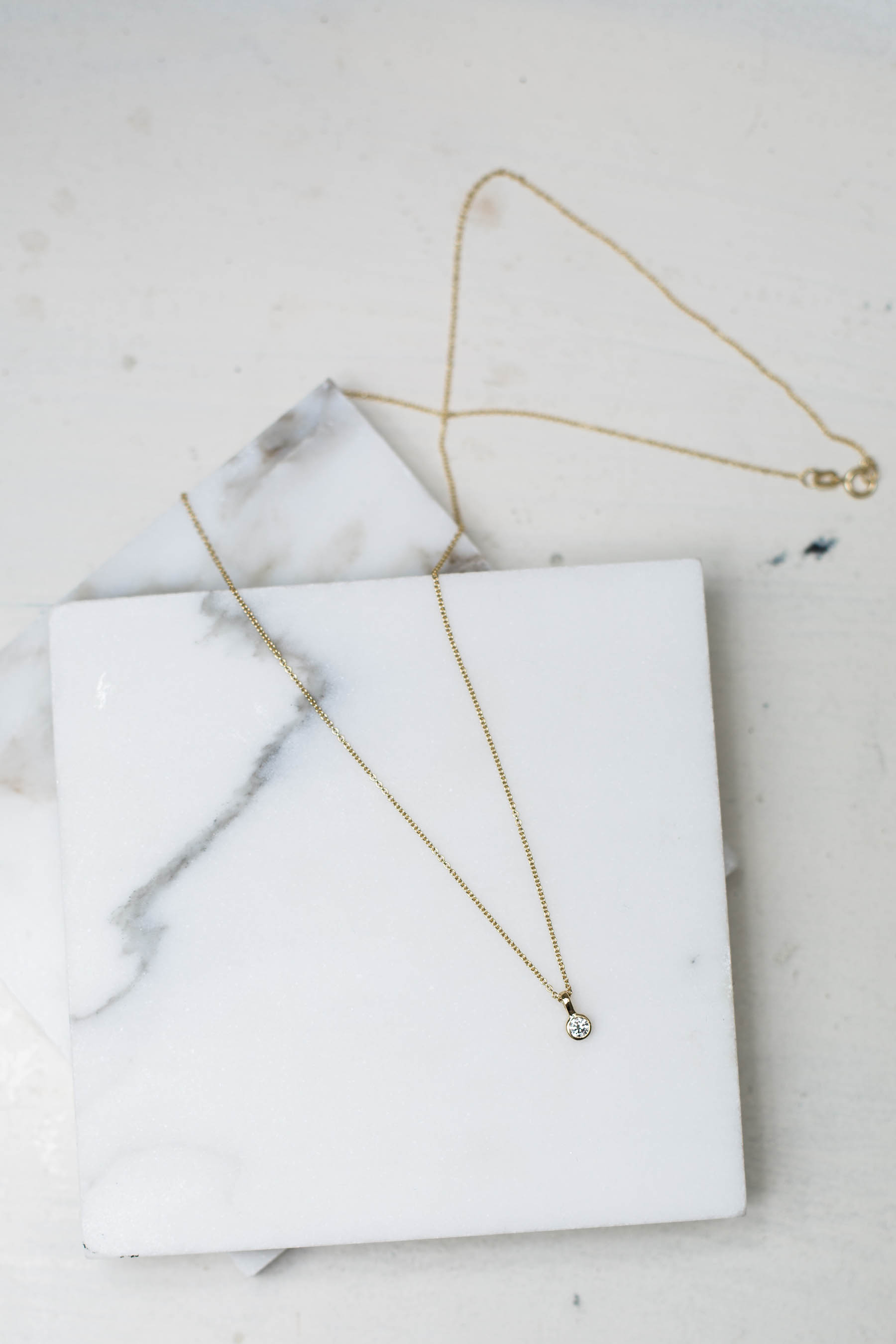 simple diamond necklace from Diamond Foundry on marble slate coaster