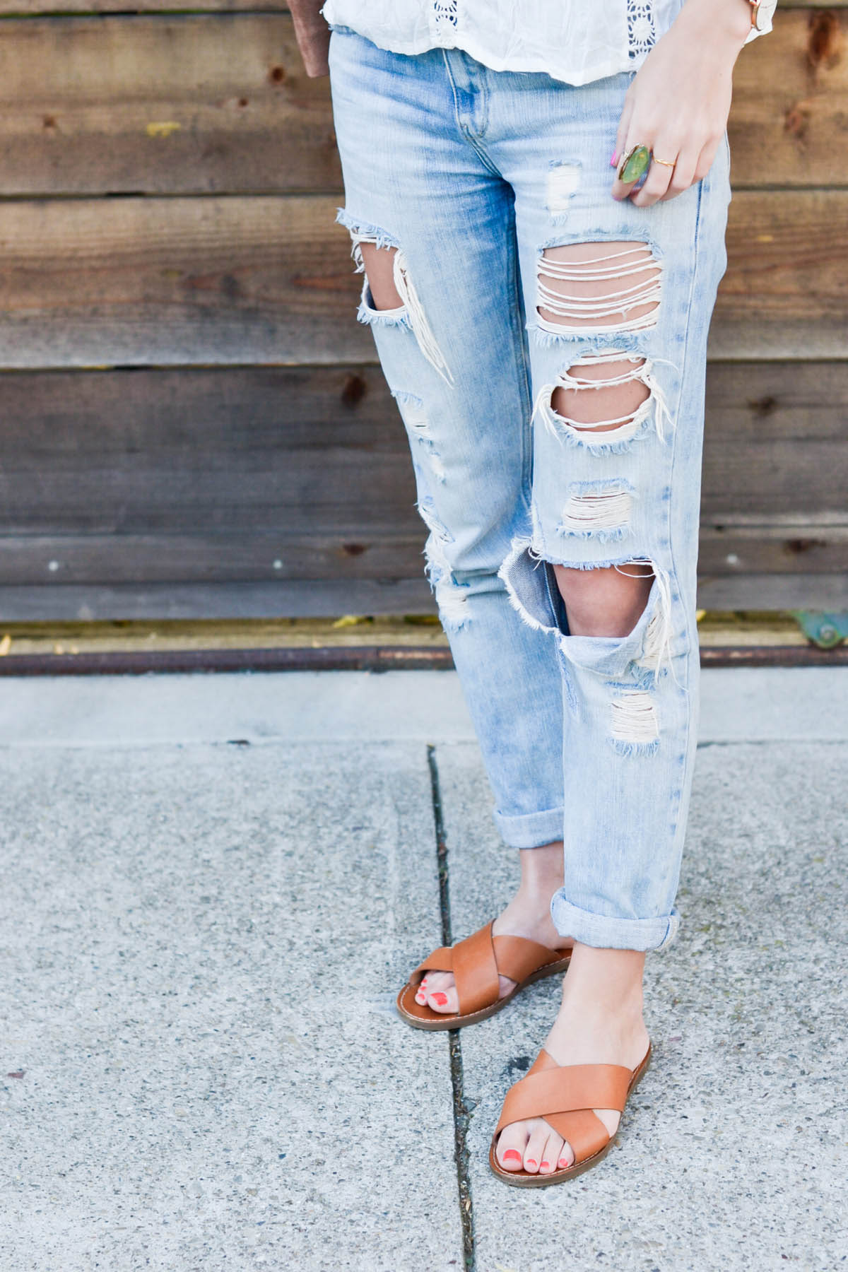 Amanda Holstein in ripped boyfriend jeans and madewell slides brown leather sandals