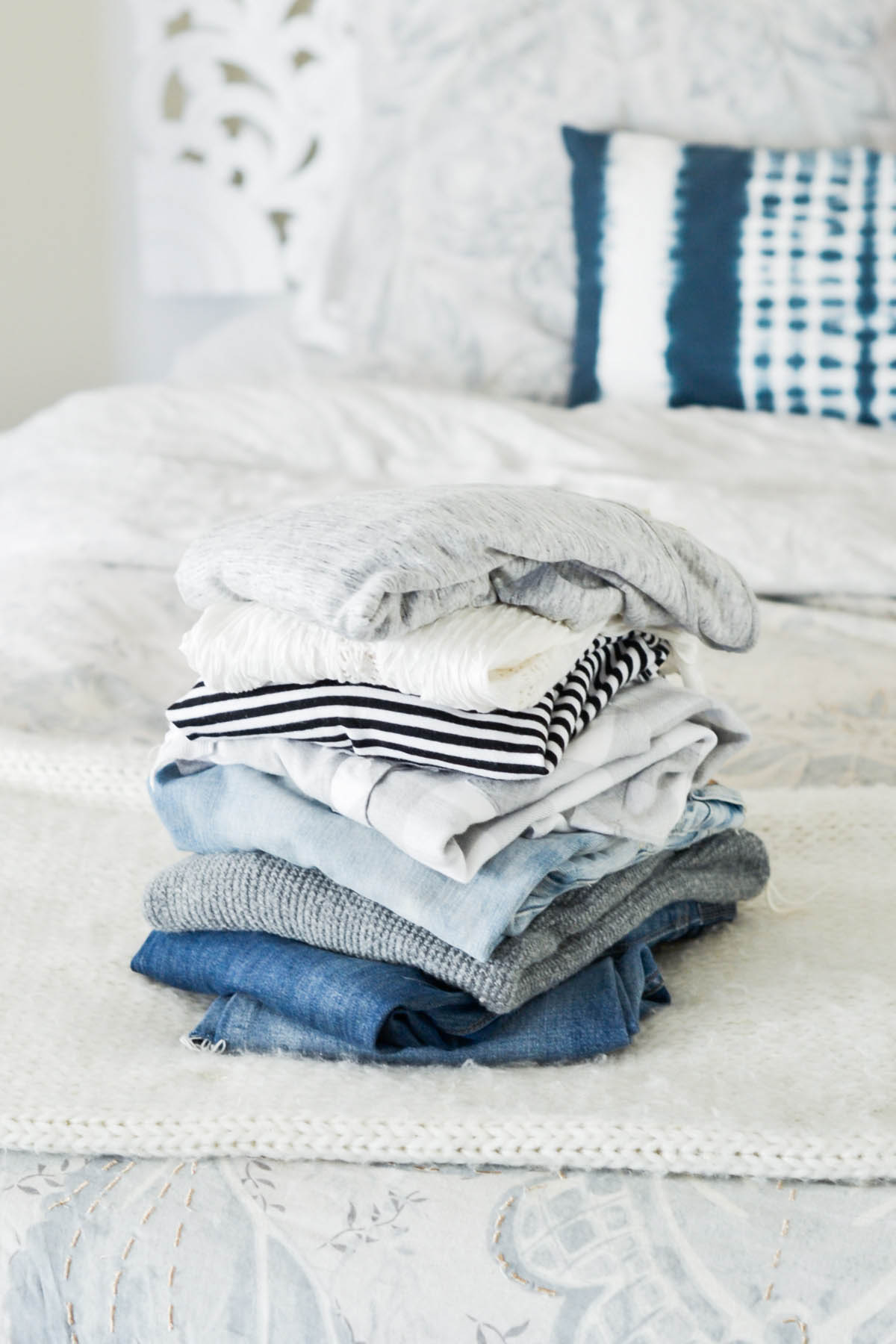 pile of clothes for capsule wardrobe including neutrals and basics