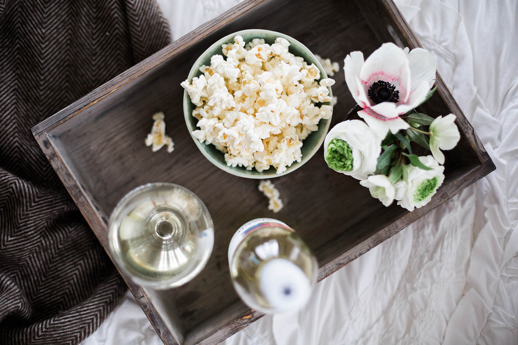 tray of popcorn and seven daughters wine on bed for movie night