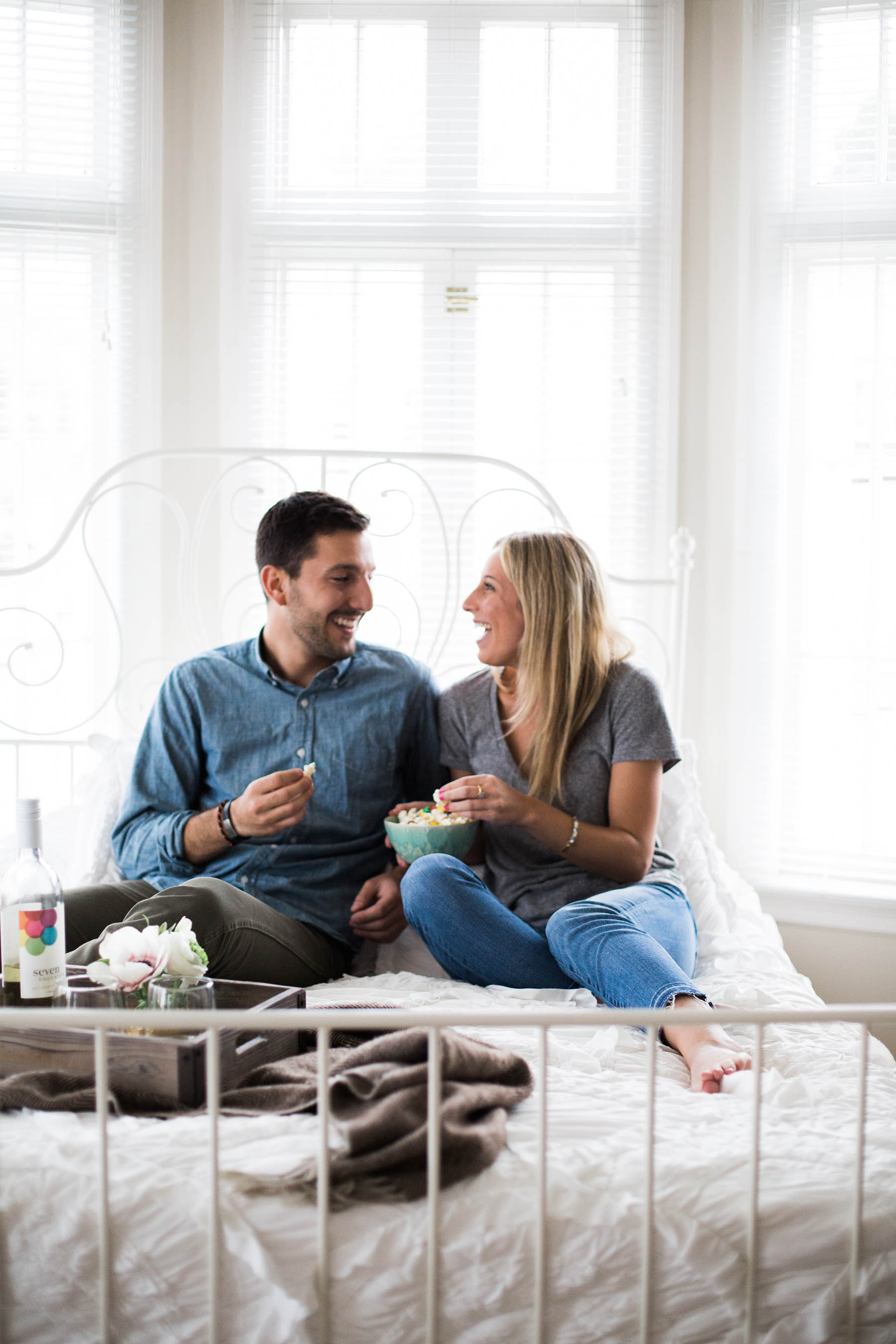 happy couple in bed eating popcorn and drinking seven daughters wine (Amanda Holstein)