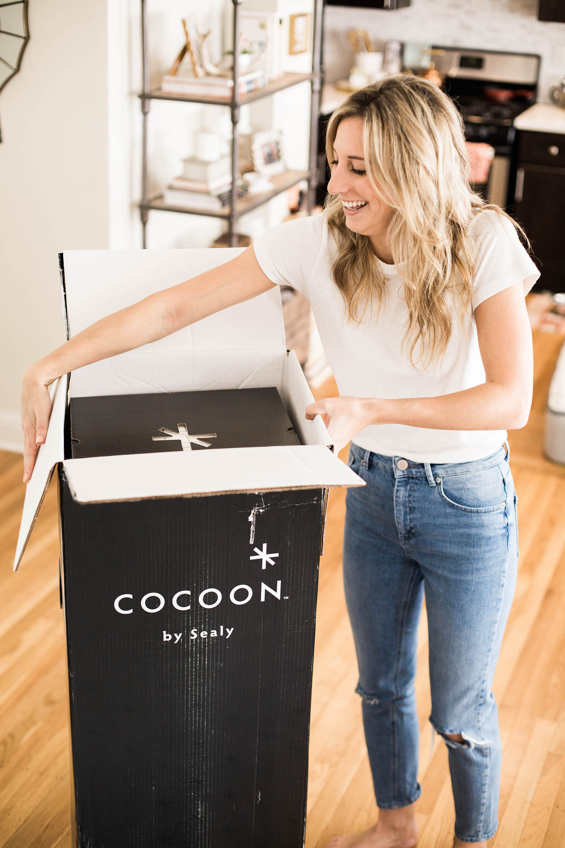 Amanda Holstein opening Cocoon by Sealy mattress delivery box