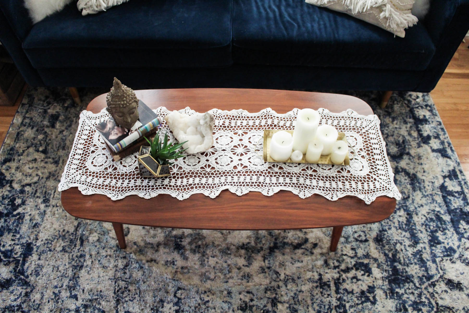 boho coffee table decor with crochet runner, candles, and Lulu & Georgia rug