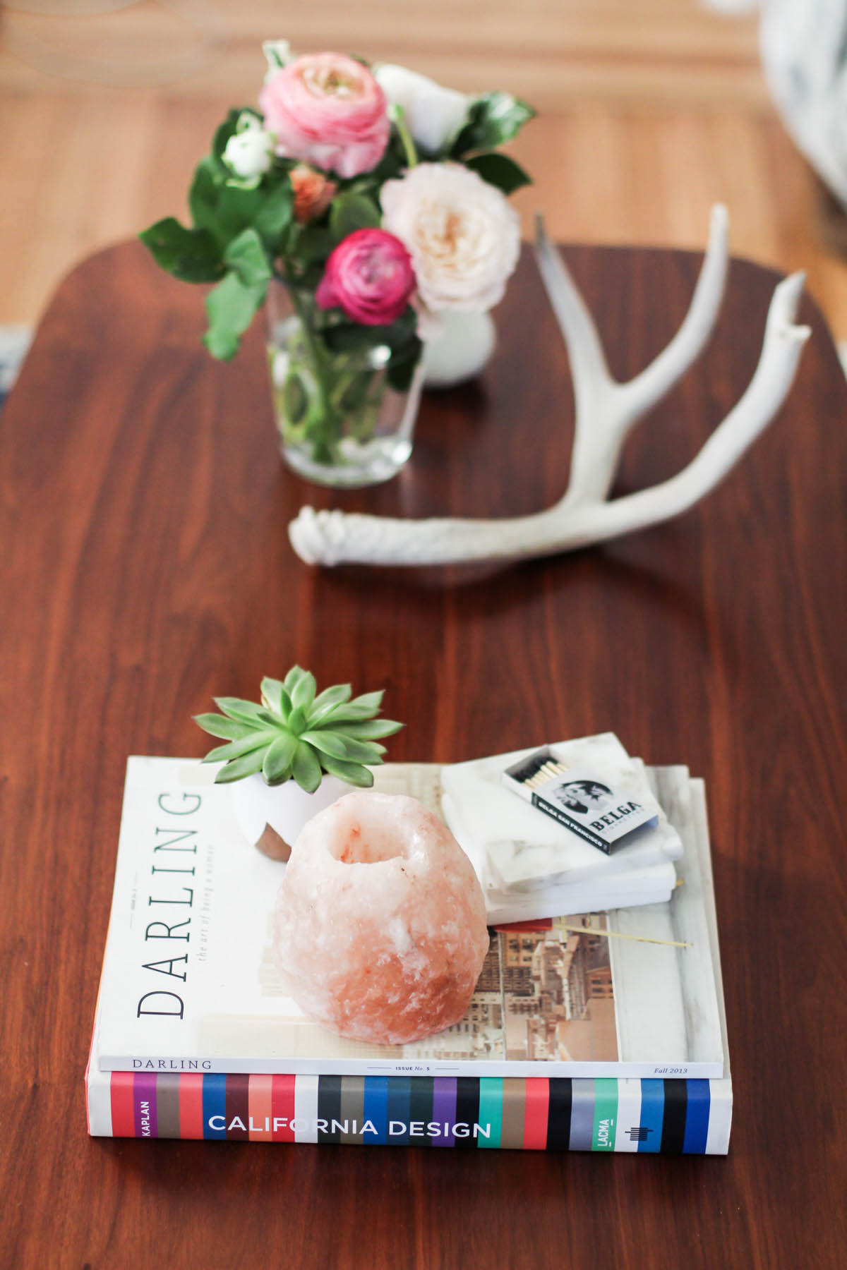 feminine coffee table styling with flowers, antlers, and geodes