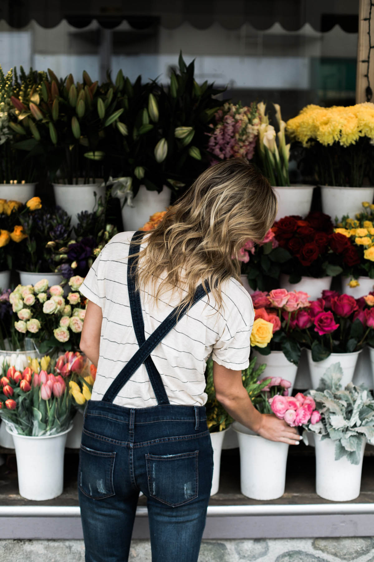 Amanda Holstein in Free People denim overalls at the Bud Stop flower stand