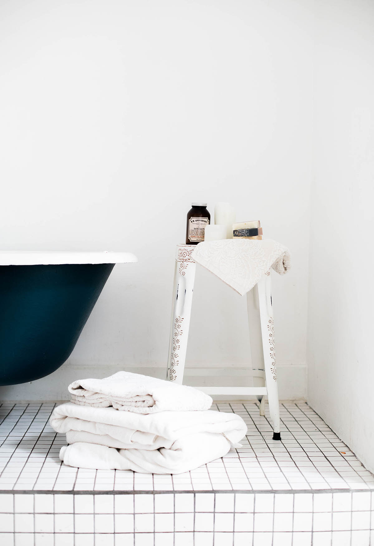 white bathroom with clawfoot tub and stool