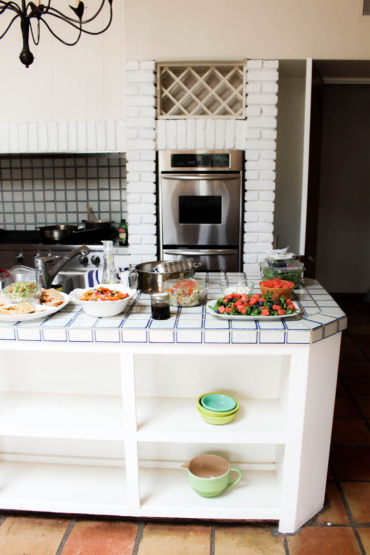 all white rustic kitchen with colorful food for family dinner