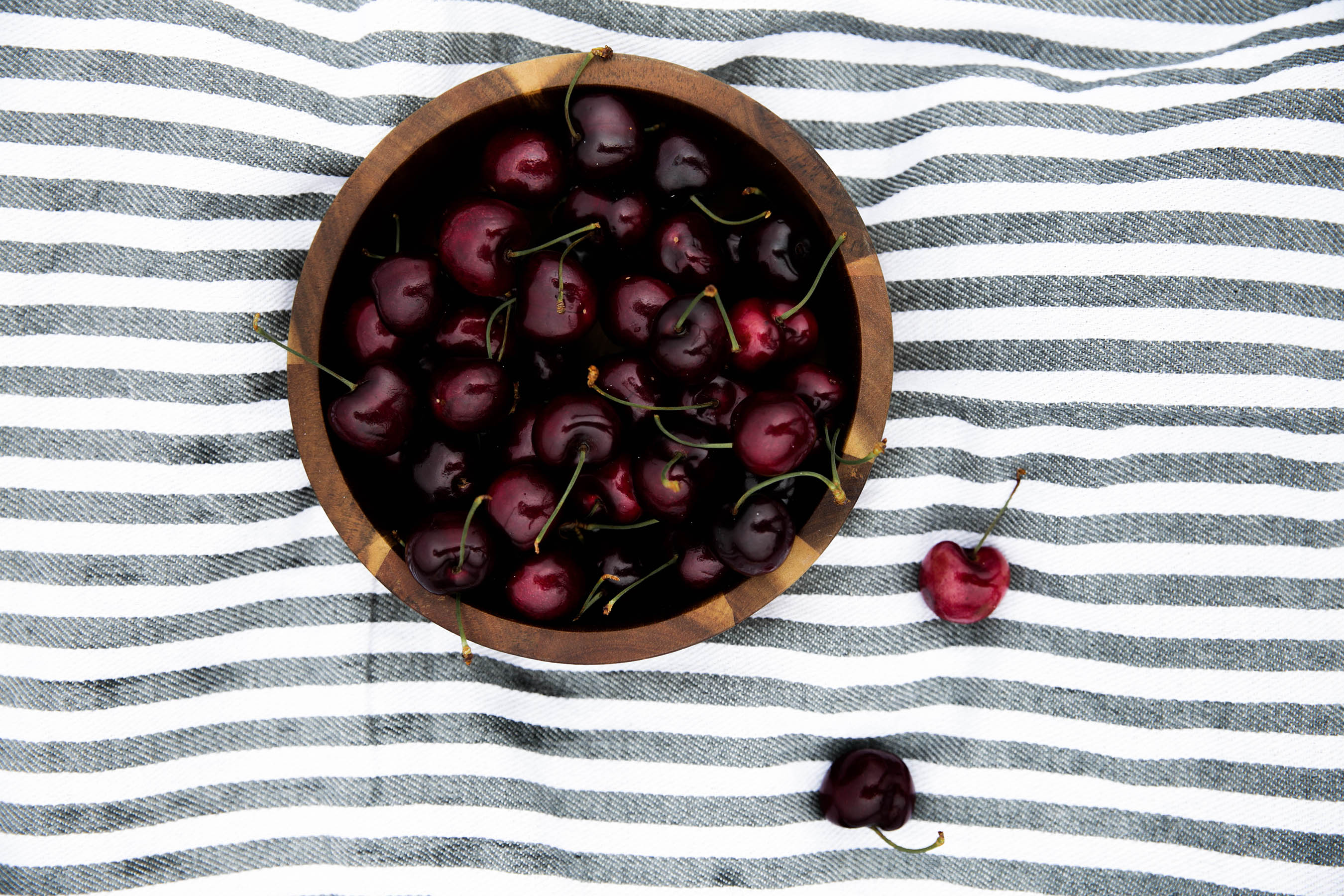 bowl of cherries on striped blanket for summer picnic