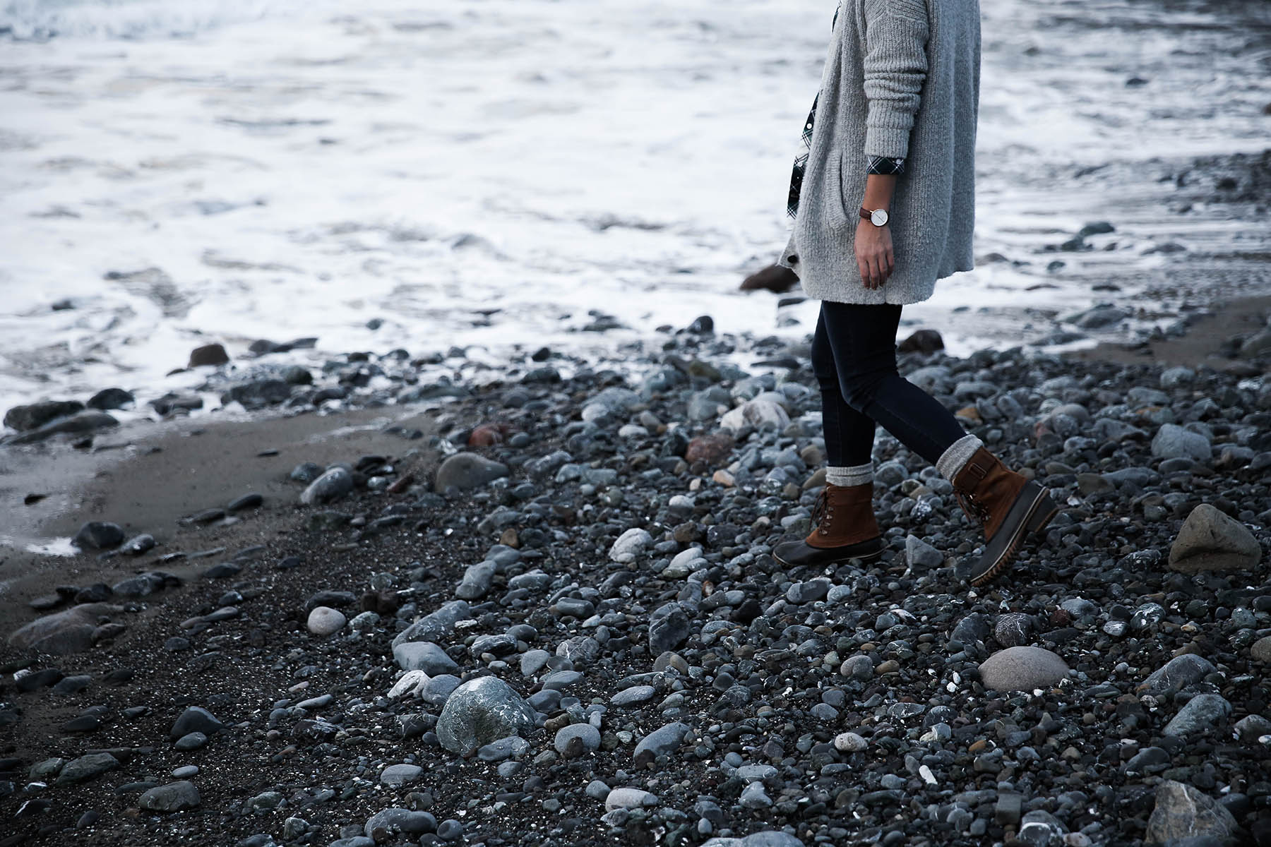 sorel boots with socks and jeans on beach