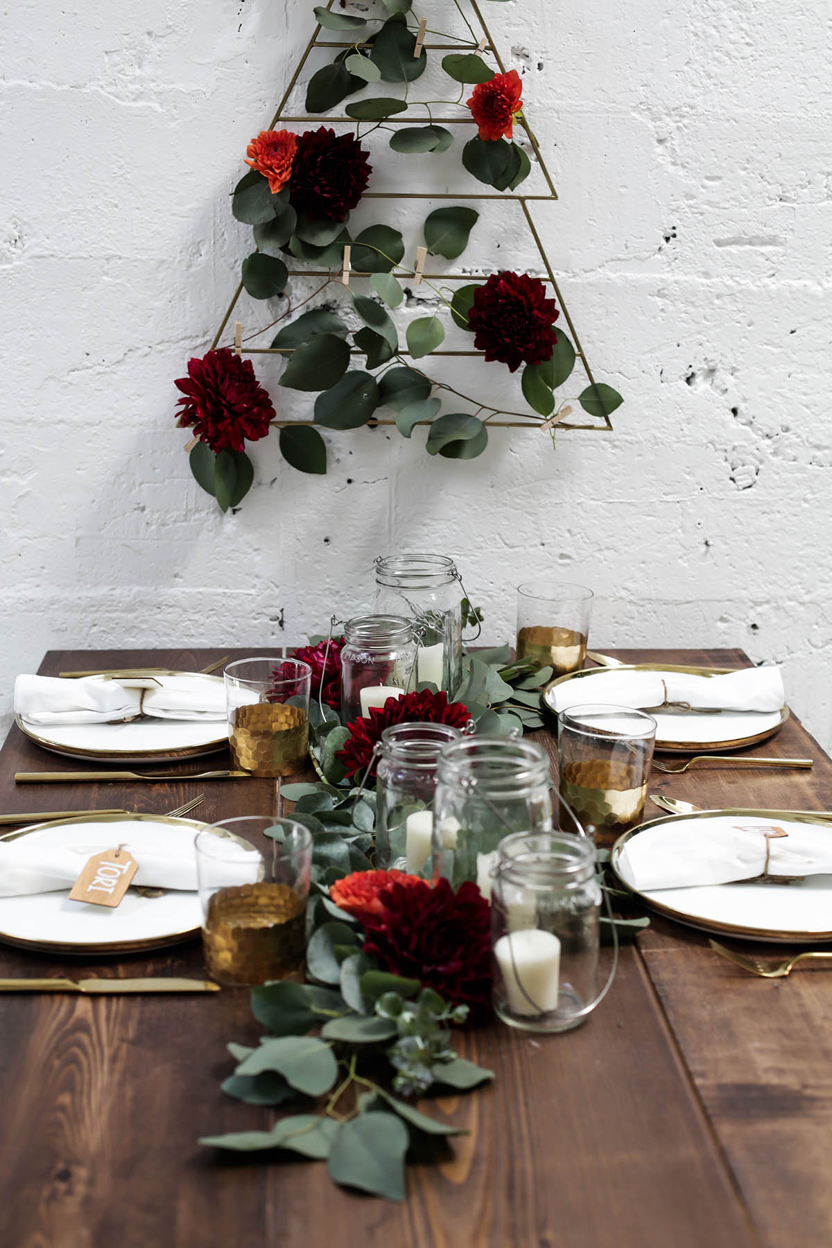 natural bohemian holiday tablescape with gold flatware, candles, mason jars, florals and eucalyptus