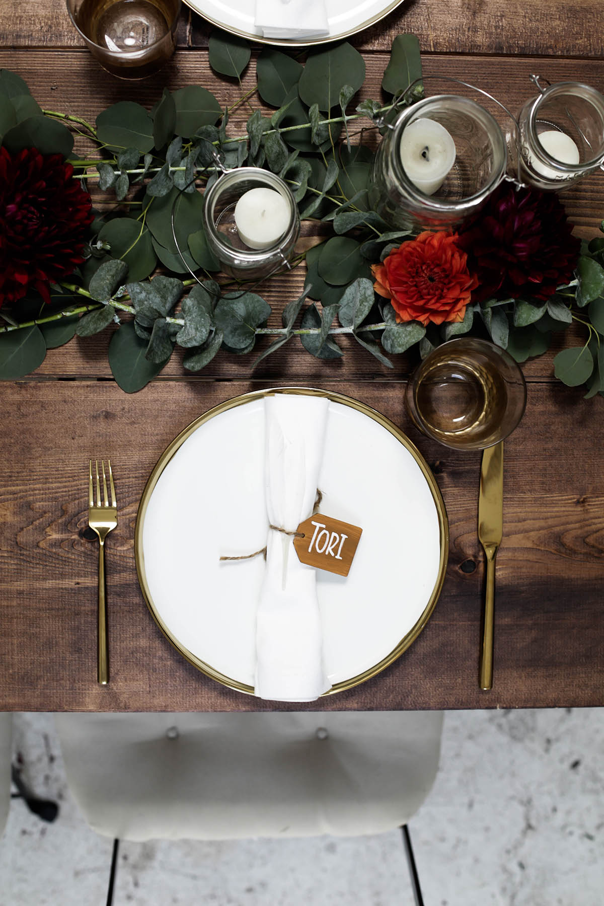 natural bohemian holiday tablescape with gold flatware, candles, mason jars, florals and eucalyptus