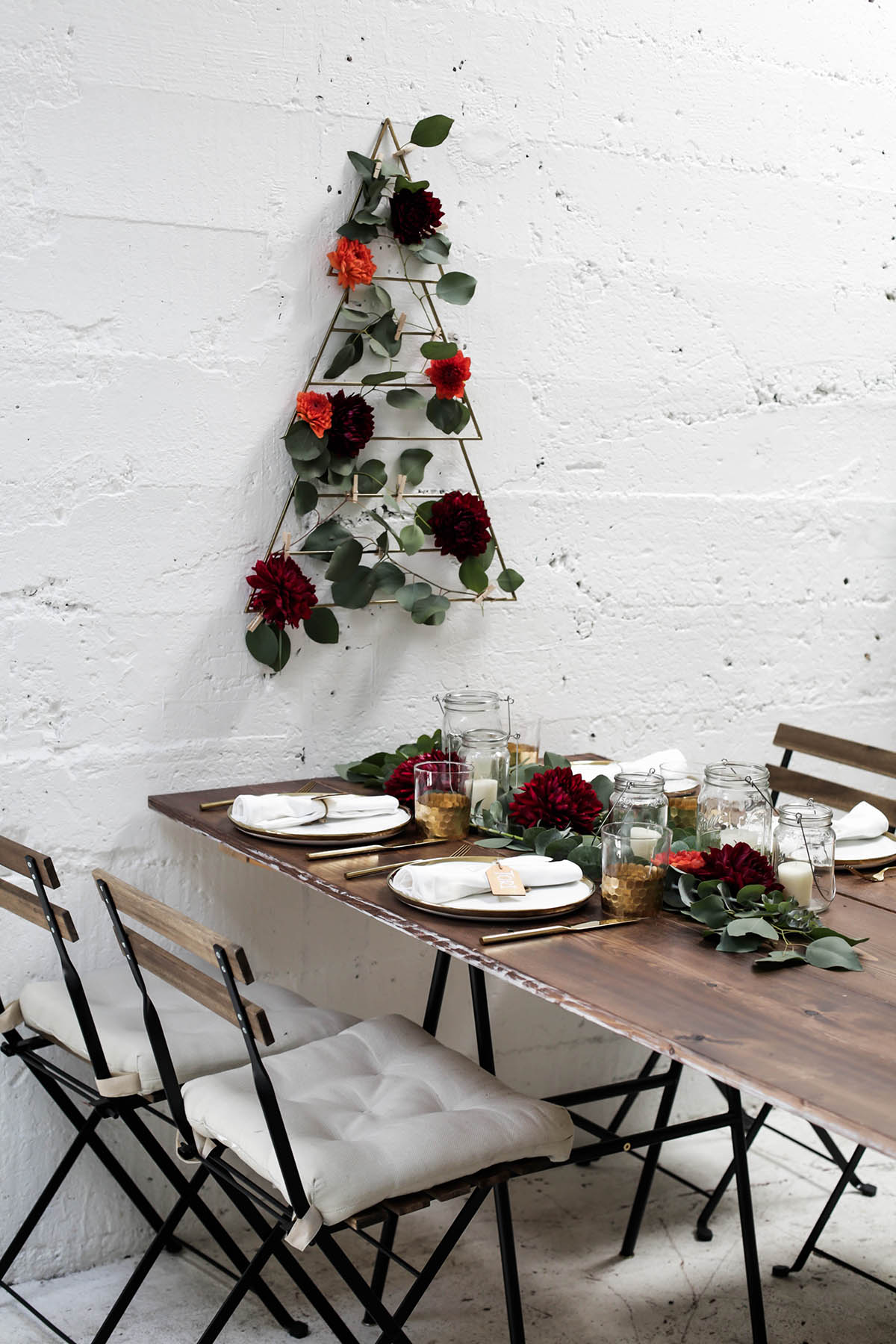 natural bohemian holiday tablescape with gold flatware, candles, mason jars, florals and eucalyptus