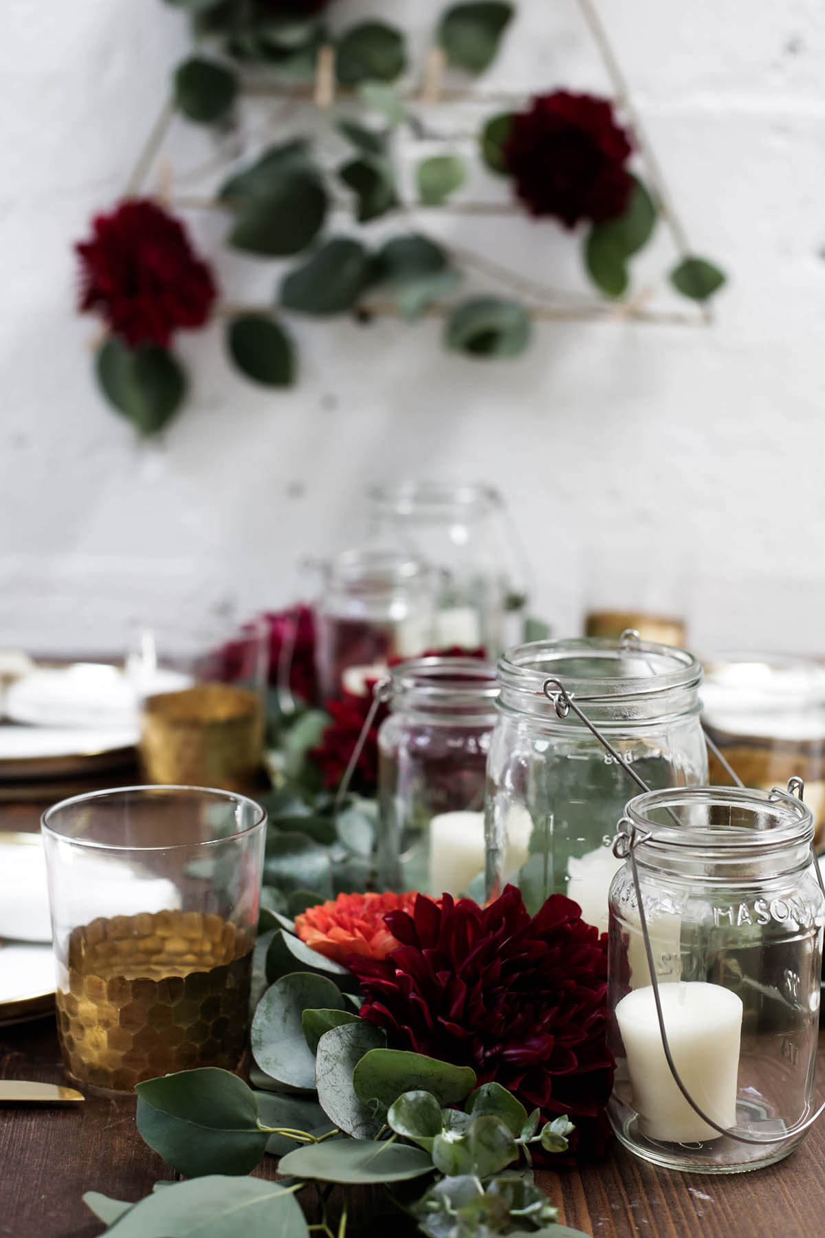 natural bohemian holiday tablescape with gold flatware, candles, mason jars, florals and eucalyptus