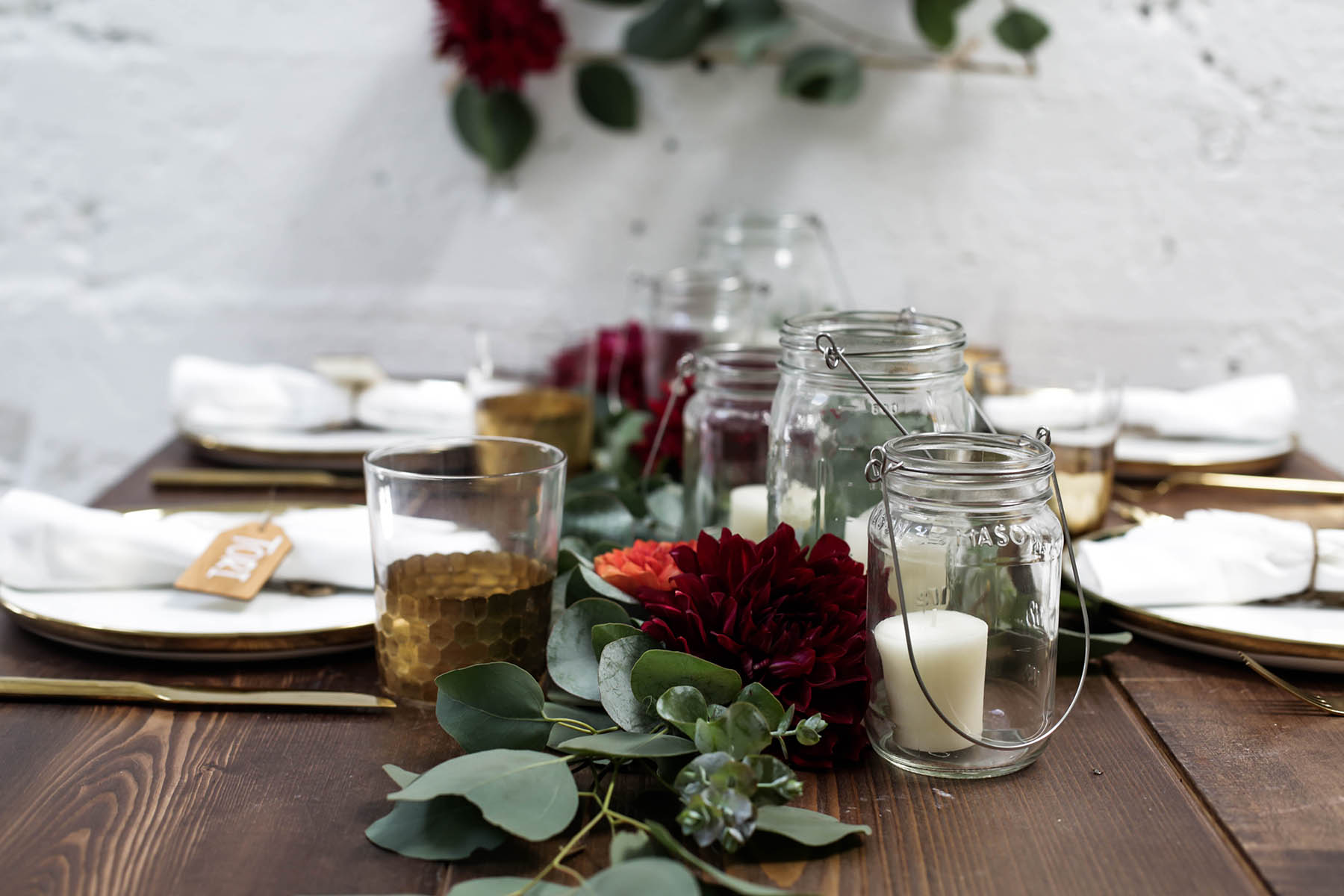 natural bohemian holiday tablescape centerpiece with candles, mason jars, florals and eucalyptus