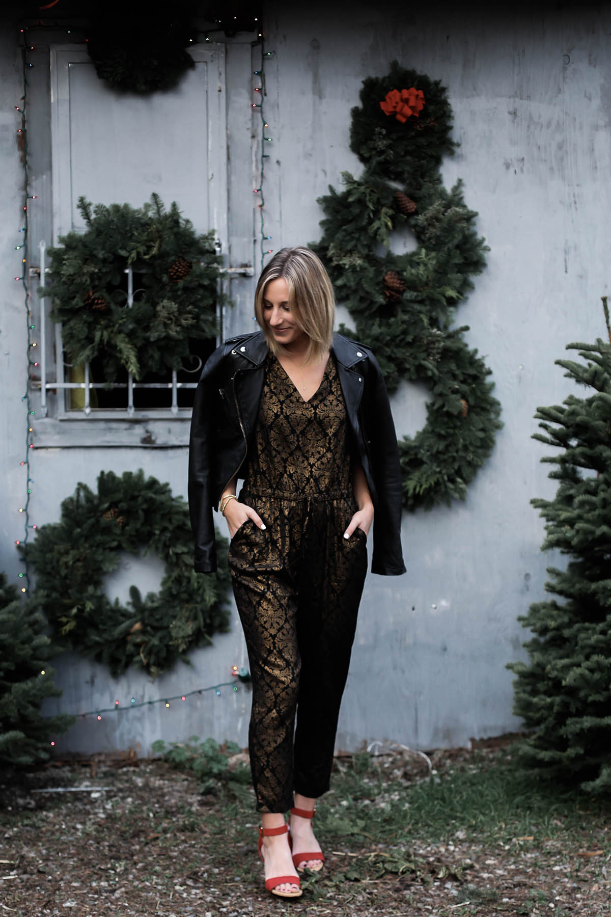 holiday jumpsuit and leather moto jacket and red shoes