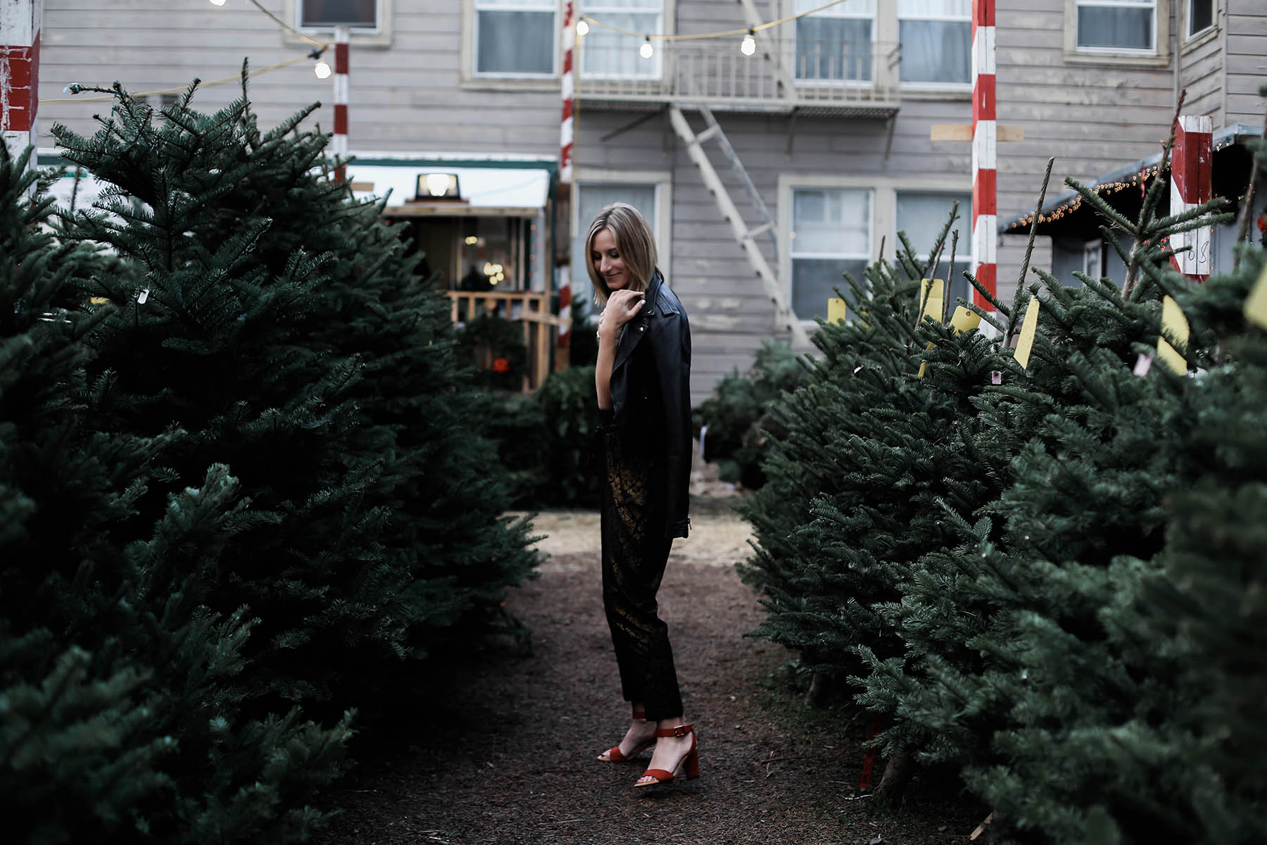 holiday jumpsuit and leather moto jacket and red shoes