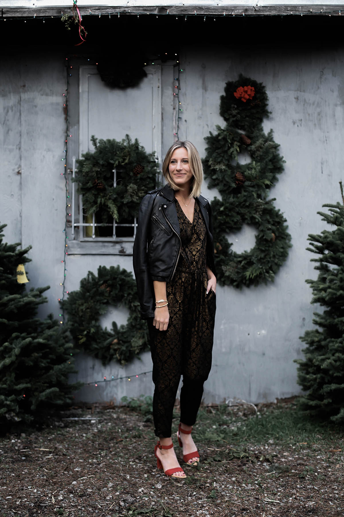 holiday jumpsuit and leather moto jacket and red shoes