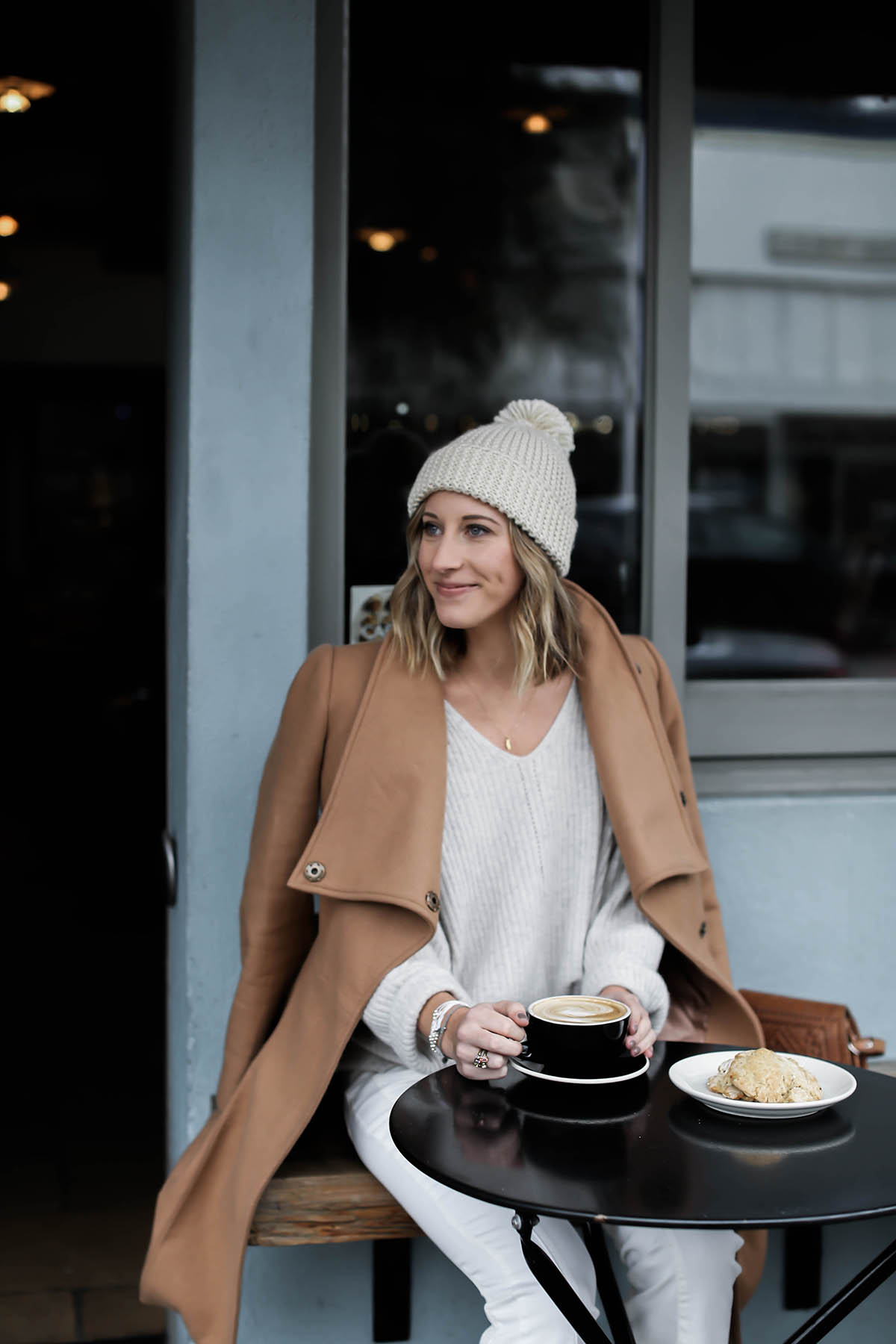 winter white outfit with pom pom beanie and camel coat
