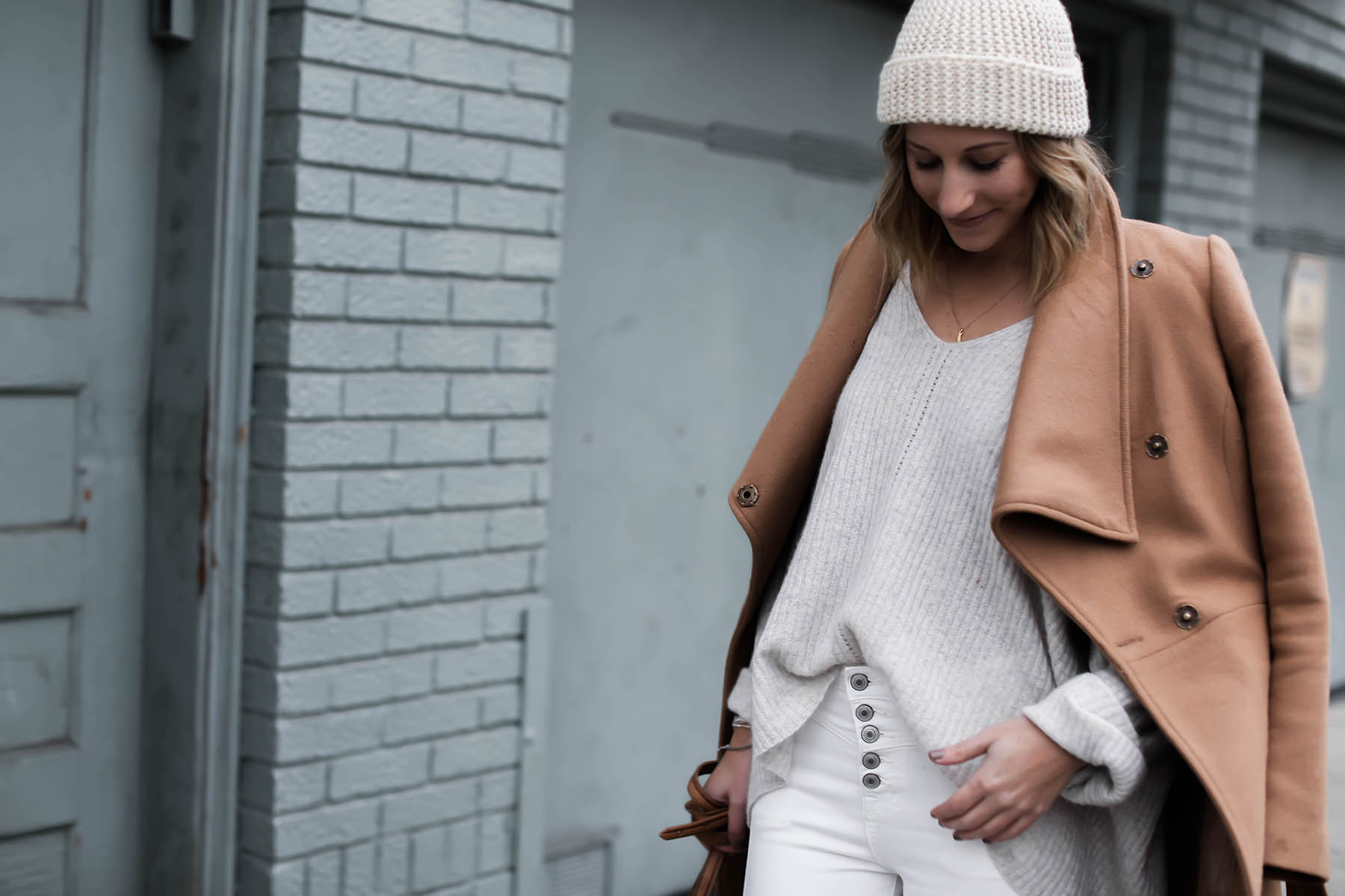 winter white outfit with pom pom beanie and camel coat