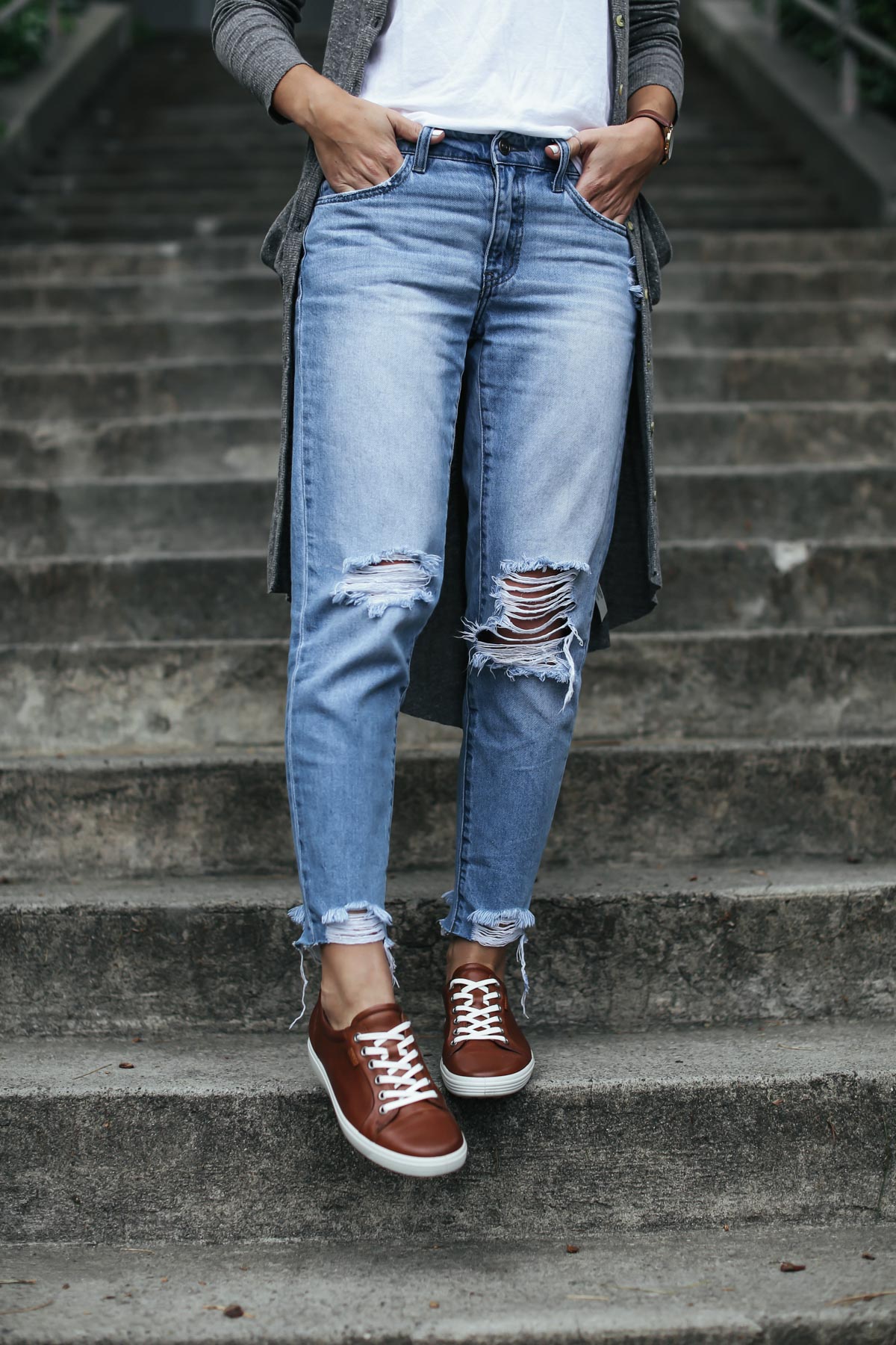 distressed boyfriend jeans and brown leather sneakers